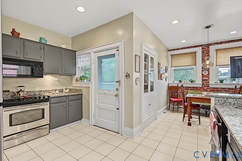 KItchen with Stainless appliances, white tile floor and granite countertops.