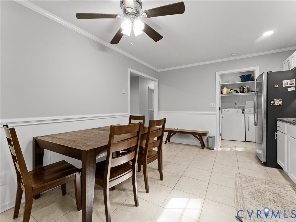 Ceramic tile flooring, crown molding, chair rail trim, and a ceiling fan with integrated lighting