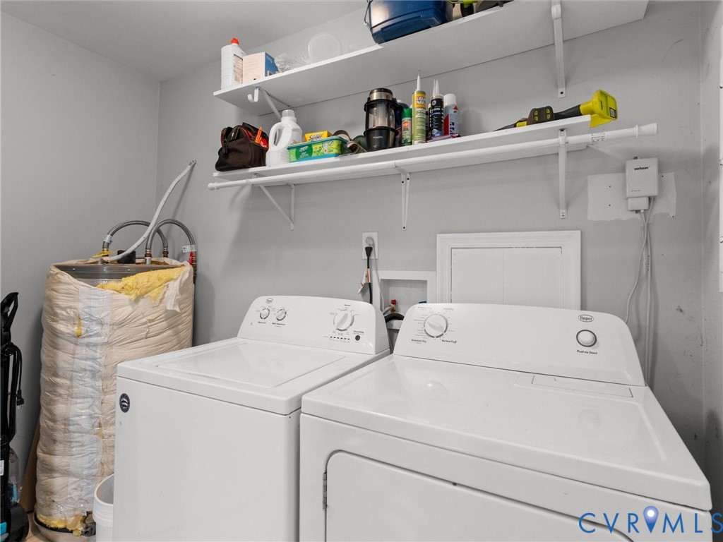 Laundry area featuring dual wall-mounted storage shelves, designated water hookups, and a water heater unit