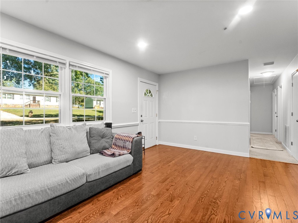 Room featuring wood-finish flooring, crisp white wall trim, and multi-pane windows providing natural light