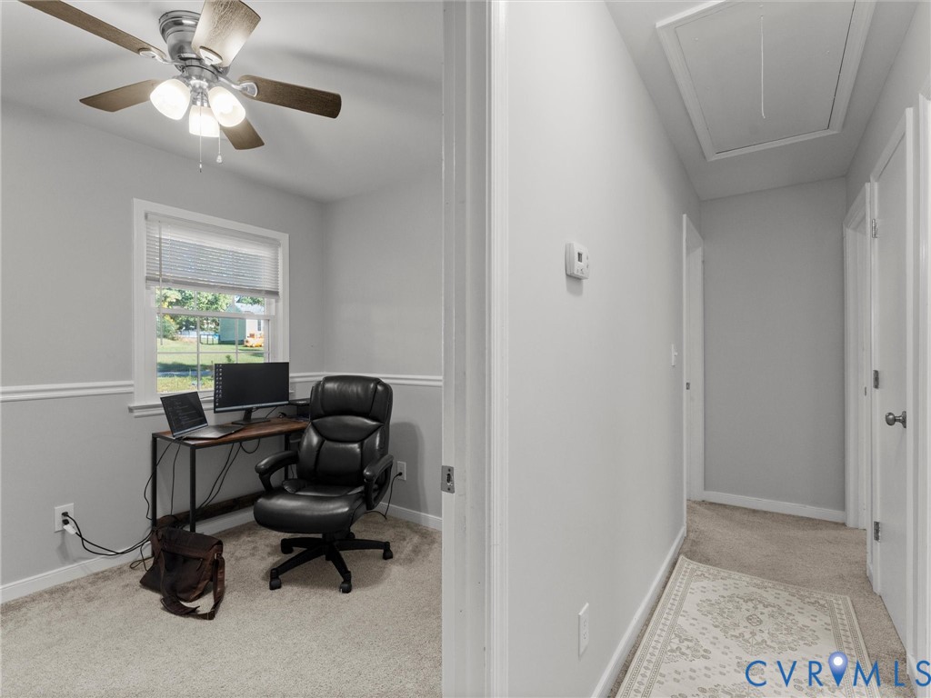 Room featuring a ceiling fan with integrated lighting, neutral wall-to-wall carpeting, wainscoting, and a window with blinds