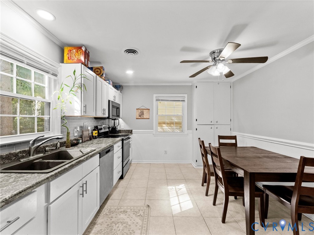 Kitchen featuring white cabinetry, stone-finish countertops, stainless steel appliances, tile flooring, and ceiling fan