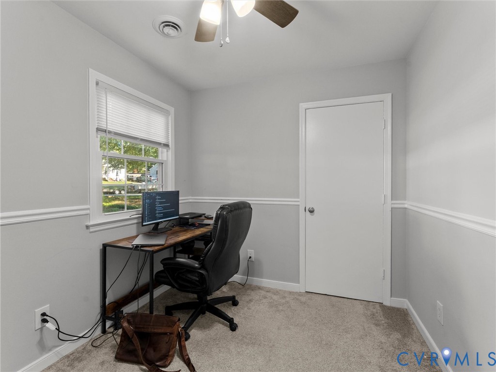 Interior room featuring neutral wall paint, white chair rail molding, wall-to-wall carpeting, a single-hung window with blinds, and a ceiling fan