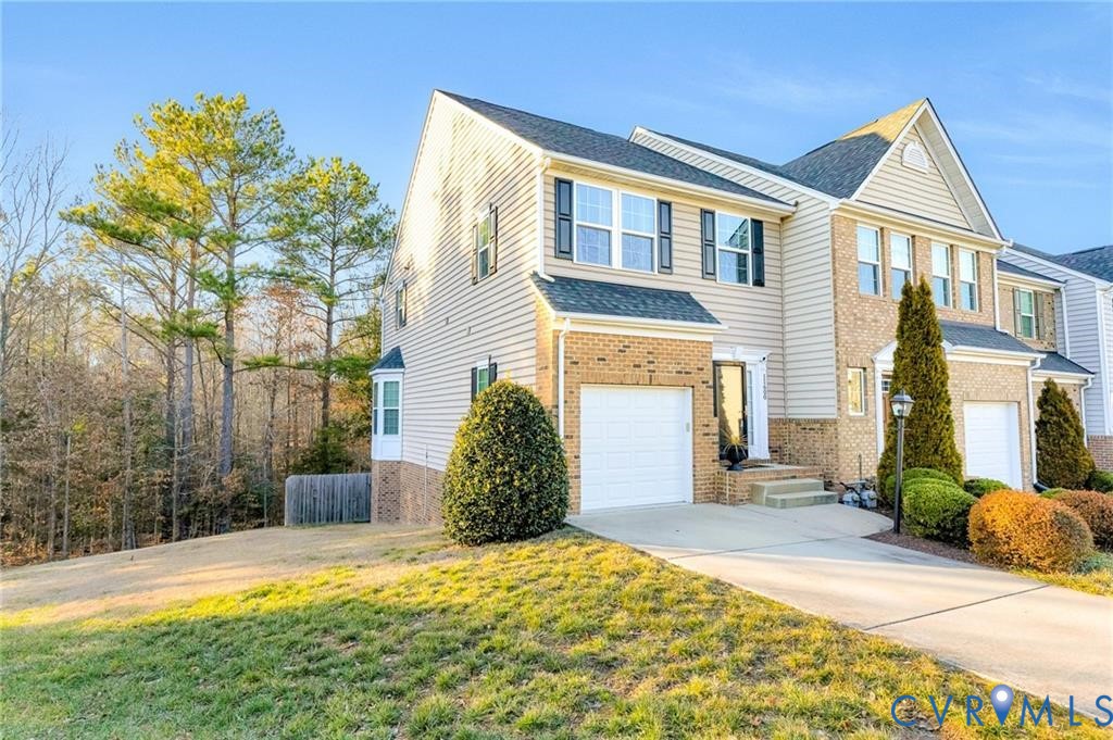 View of front of home with brick siding, a front lawn, fence, driveway, and an attached garage View of front of home with brick siding, a front lawn, fence, driveway, and an attached garage