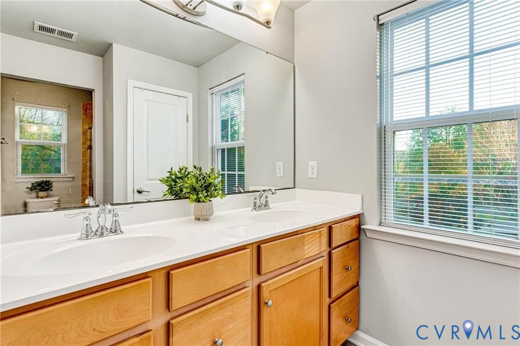 Full bathroom featuring plenty of natural light, visible vents, and a sink