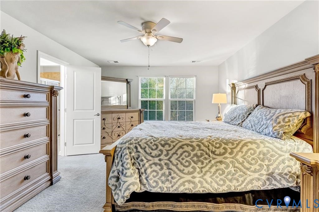 Bedroom with a ceiling fan and light colored carpet