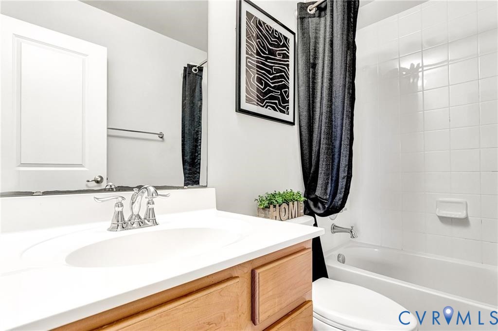 Bathroom with toilet, shower / bath combo, and vanity