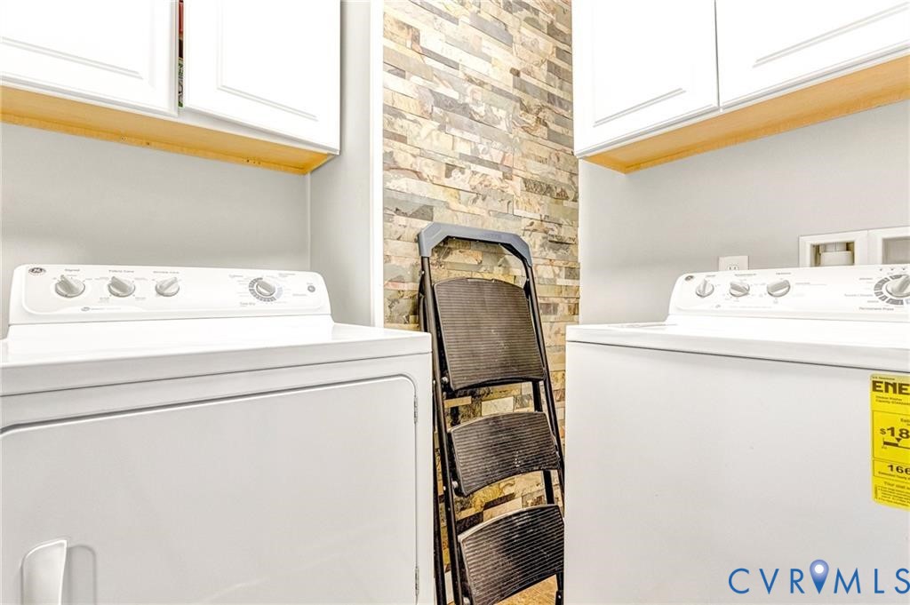 Washroom with cabinet space and washing machine and clothes dryer
