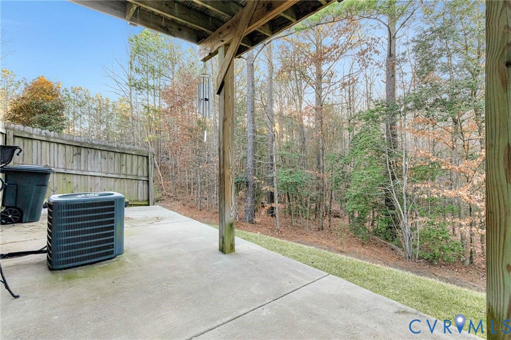 View of patio featuring central AC unit and fence