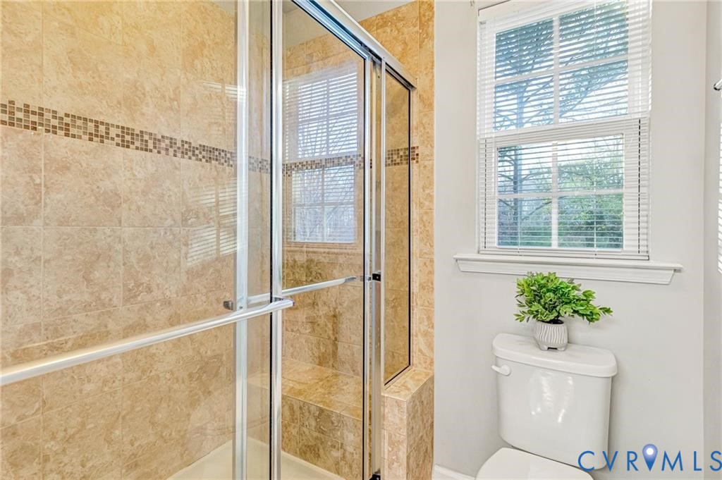 Bathroom featuring a shower stall and toilet