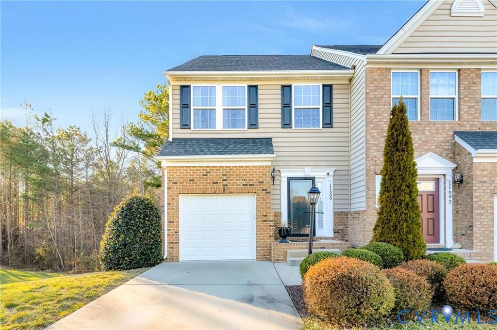 View of front of house with concrete driveway, a garage, brick siding, and a shingled roof View of front of house with concrete driveway, a garage, brick siding, and a shingled roof