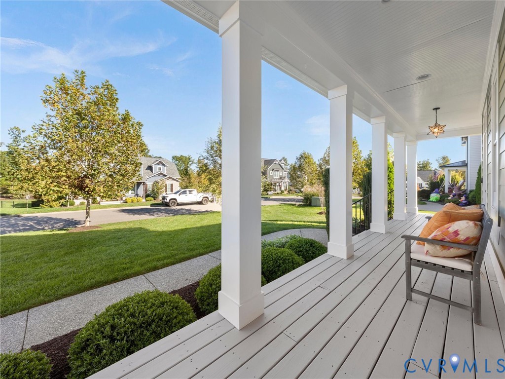 Covered front porch featuring white square columns, tongue-and-groove ceiling, painted wood-finish decking, and pendant lighting Covered front porch featuring white square columns, tongue-and-groove ceiling, painted wood-finish decking, and pendant lighting