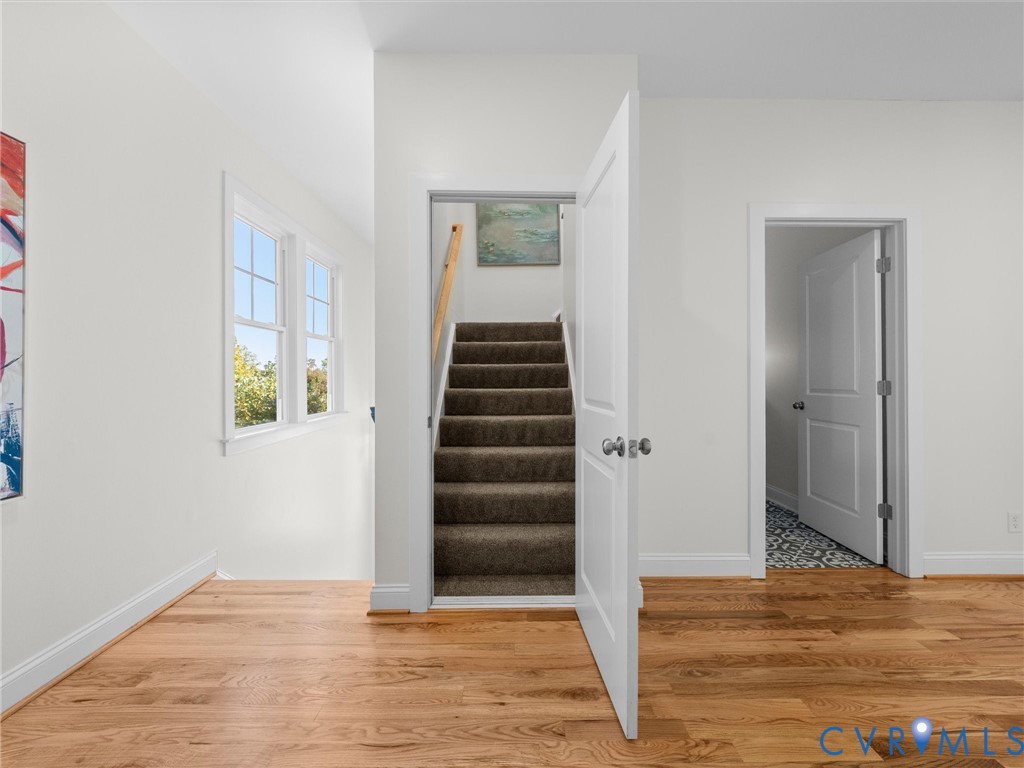 Wood-finish flooring, double-pane windows, carpeted staircase, and multi-panel interior doors
