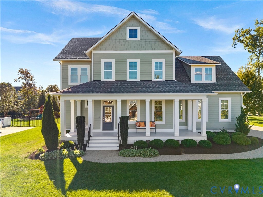Two-story home featuring horizontal lap and shake siding, a covered front porch with column supports, and an asphalt shingle roof Two-story home featuring horizontal lap and shake siding, a covered front porch with column supports, and an asphalt shingle roof
