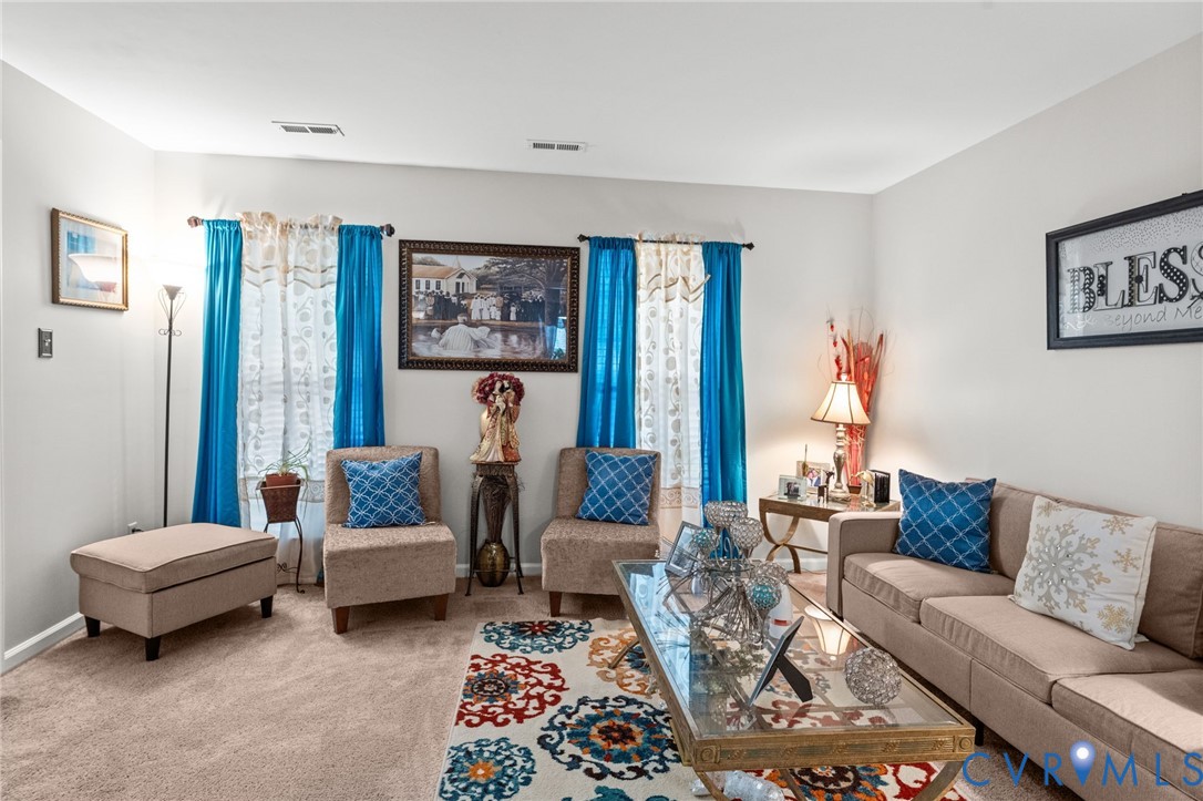 Neutral-toned interior space featuring carpeted flooring and dual windows with window hardware