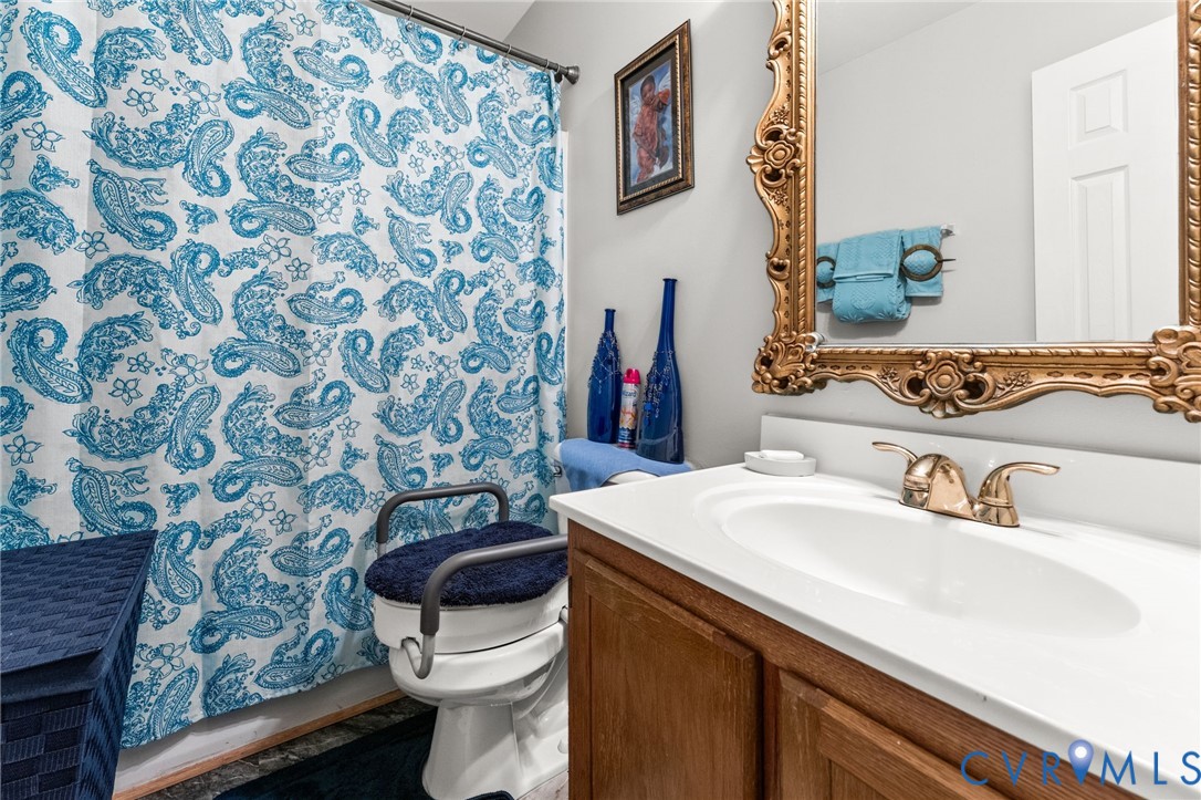 Vanity featuring a wood-finish cabinet, integrated countertop with oval basin, and dual-handle metal faucet