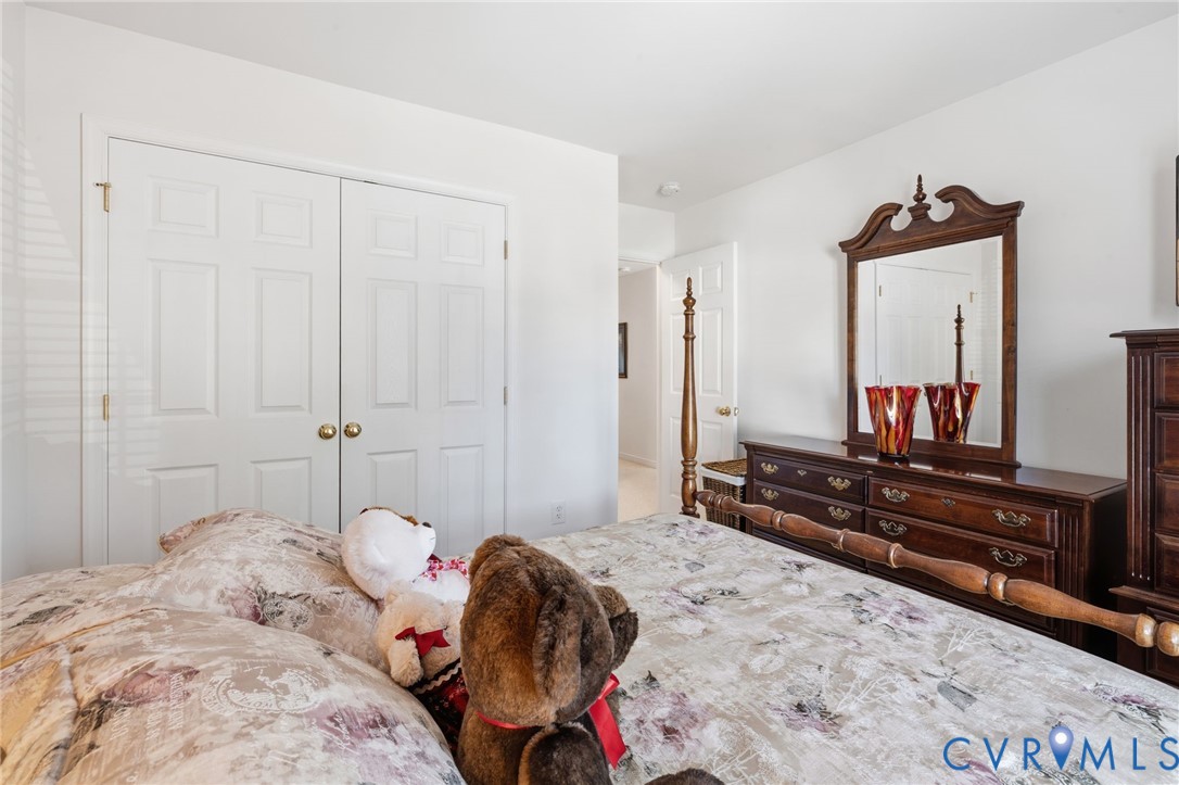 Double-door reach-in closet featuring white panel doors and brass hardware