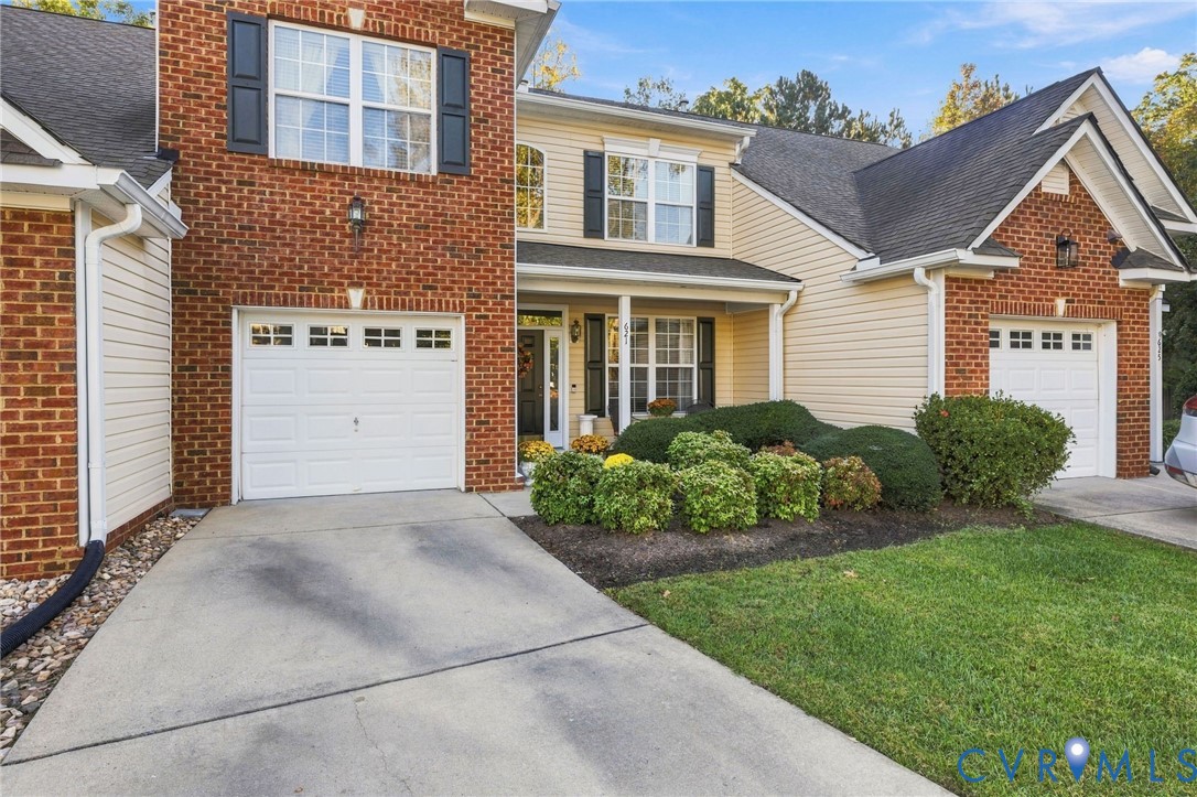 Multi-level exterior featuring a combination of brick and siding, dual attached garages, a covered front entryway, and manicured landscaping Multi-level exterior featuring a combination of brick and siding, dual attached garages, a covered front entryway, and manicured landscaping