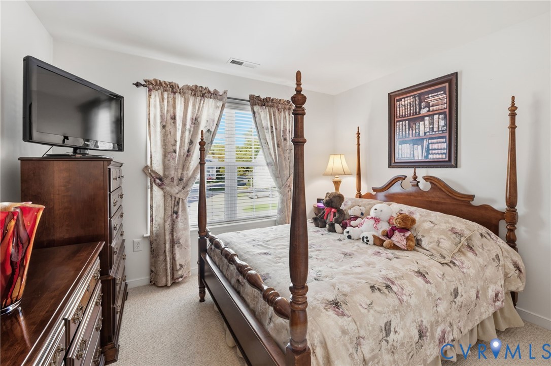 Neutral wall palette featuring carpeted flooring and a multi-pane window with horizontal blinds