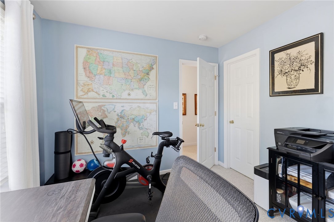 Room featuring light blue walls, neutral carpeting, and two white paneled doors