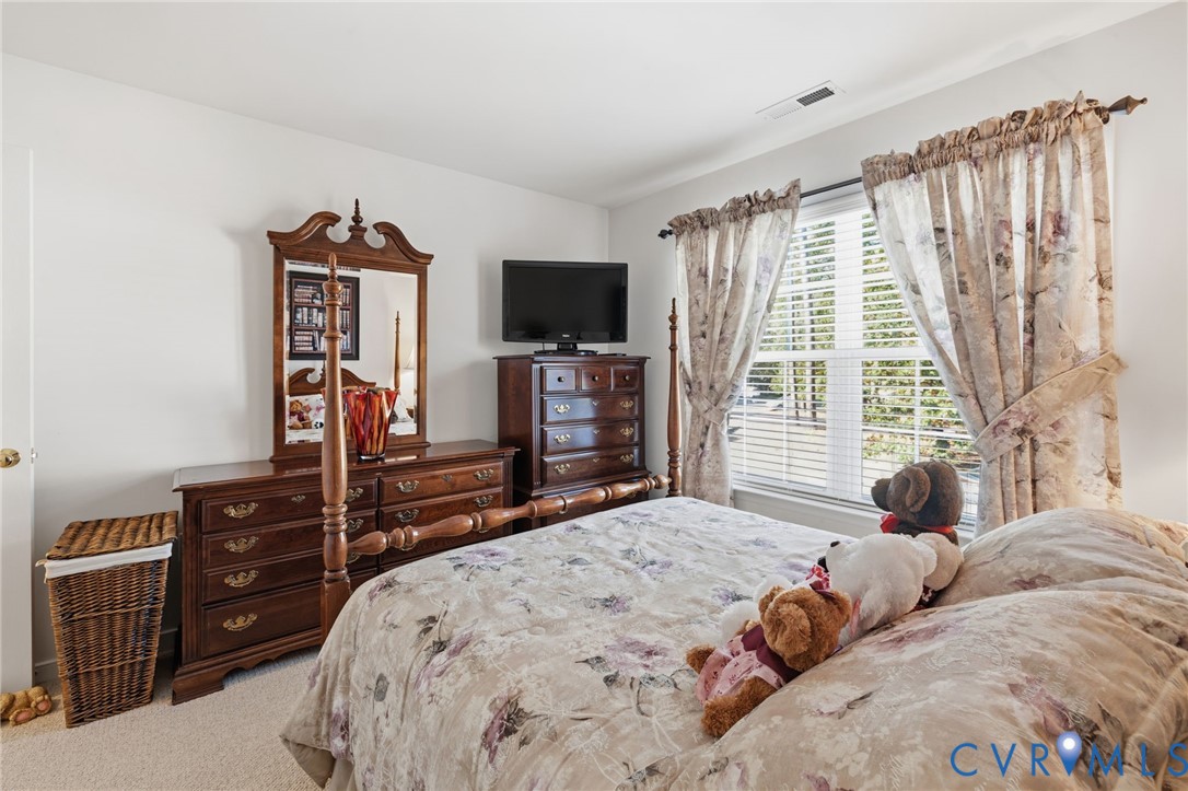 Bedroom featuring wall-to-wall carpeting and a double-pane window with horizontal blinds
