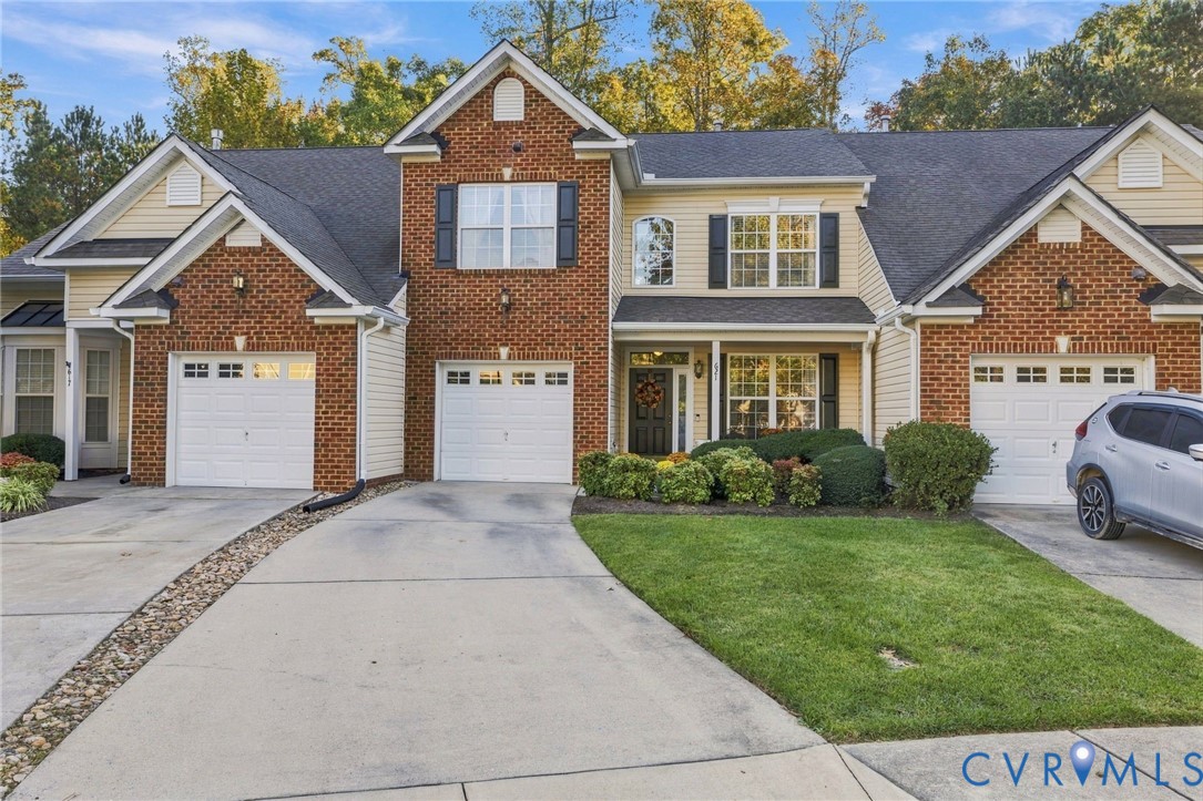 Multi-family exterior featuring brick and horizontal siding, multiple gabled rooflines, two attached garages, and a concrete driveway Multi-family exterior featuring brick and horizontal siding, multiple gabled rooflines, two attached garages, and a concrete driveway