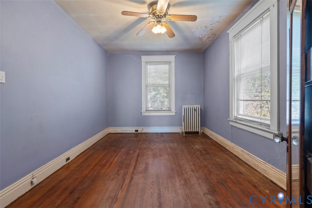 2nd bedroom featuring wood-finish flooring, two double-hung windows.