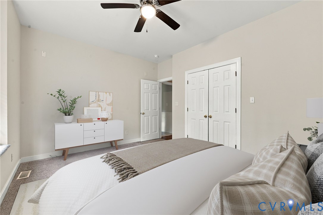 Room featuring neutral wall paint, carpeting, a ceiling fan with integrated lighting, and a double-door closet. Virtually staged concept