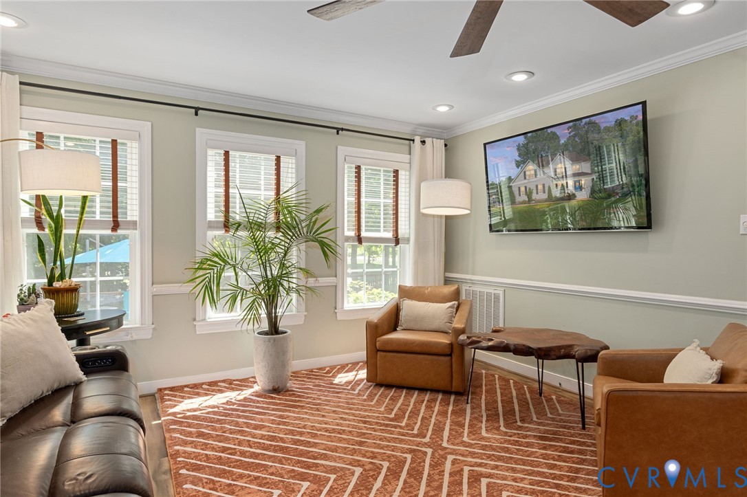 Three windows with multi-pane glazing, recessed ceiling lighting, crown molding, chair rail molding, and a ceiling fan