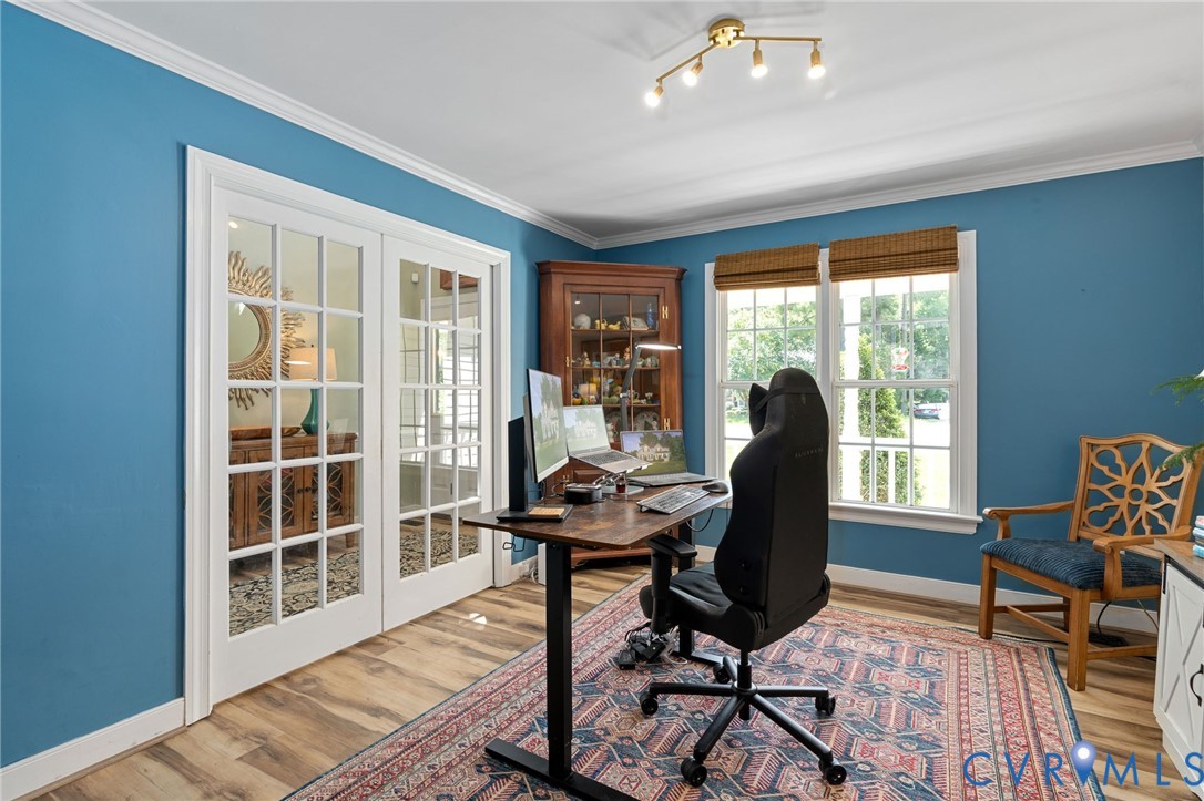 French-style double doors with glass panes, wood-finish flooring, multi-light ceiling fixture, and double windows with woven wood shades