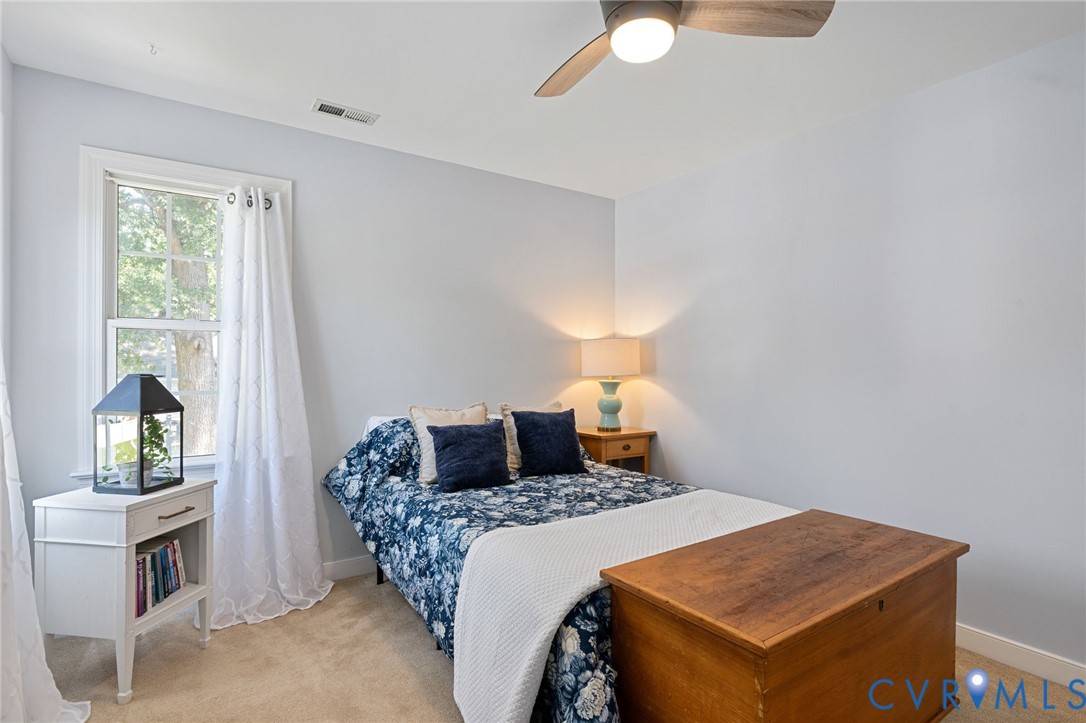 Neutral wall color, ceiling fan with light fixture, and window with natural light
