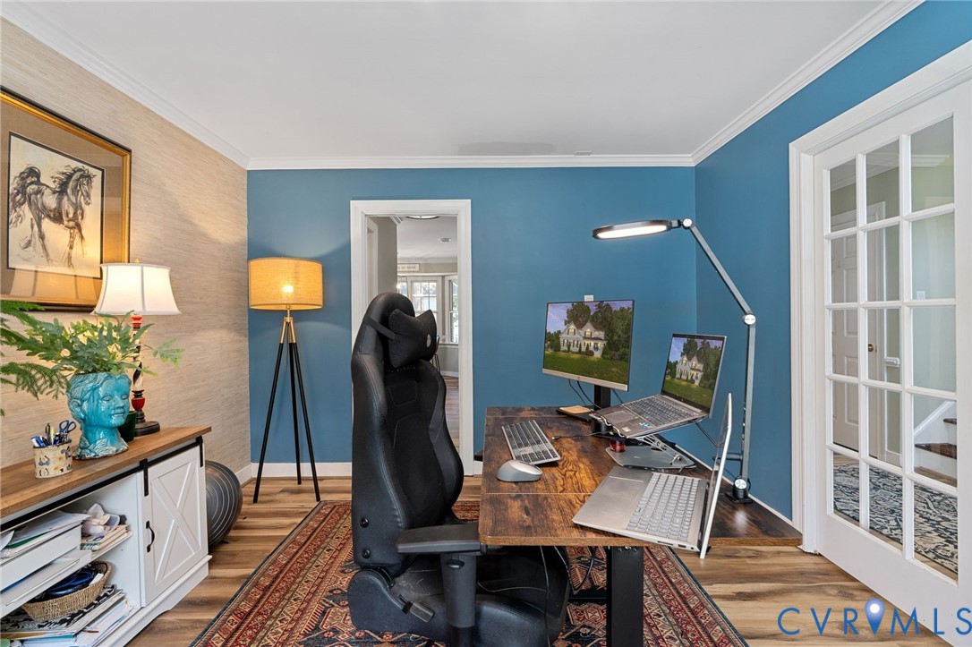 Wood-finish flooring, textured accent wall, and glass-paned French doors