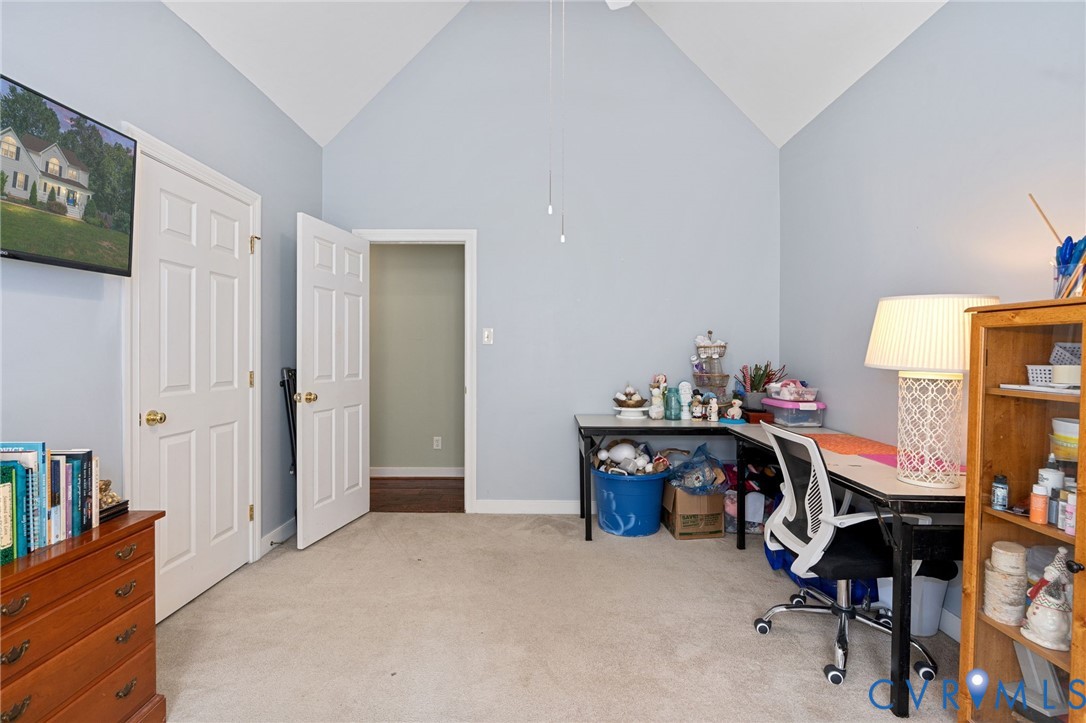 Vaulted ceiling, neutral wall tones, six-panel interior doors, and carpeted flooring