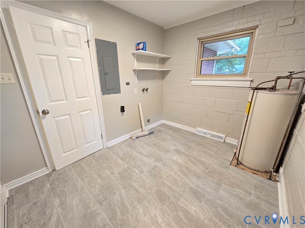 Utility/Laundry Room featuring tile flooring, painted masonry walls, built-in shelving, and a six-panel door.  200-amp electrical service.