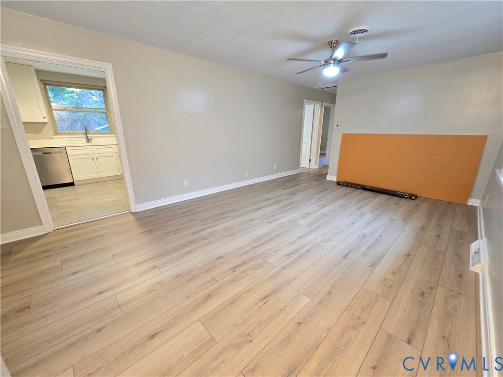 Front door entry into your spacious Family Room featuring LVP flooring, a ceiling fan with integrated lighting, and neutral wall paint