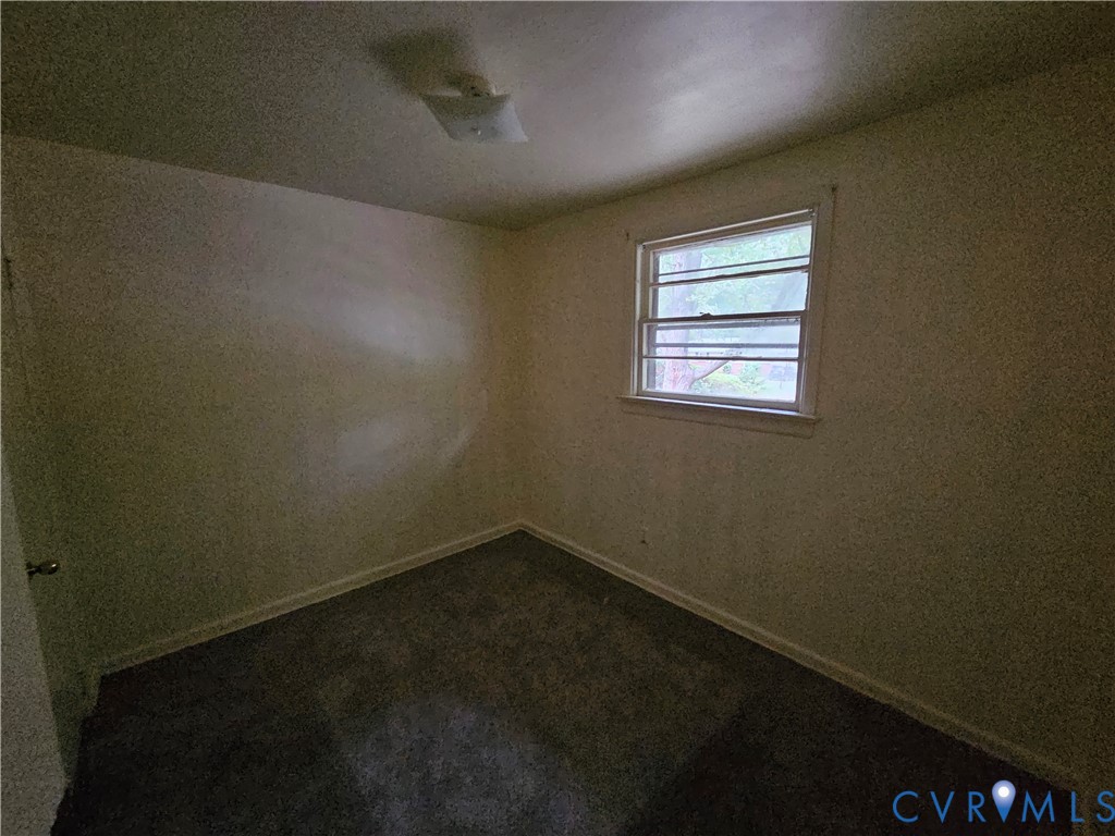 Neutral-toned walls, carpeted flooring, window with a horizontal grid pattern, and a flush-mount ceiling light fixture Neutral-toned walls, carpeted flooring, window with a horizontal grid pattern, and a flush-mount ceiling light fixture
