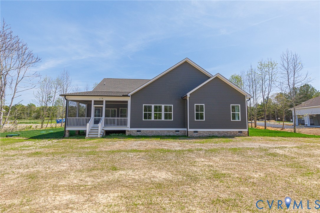 The property features grey siding, a screened-in porch with white railings, and a gravel foundation