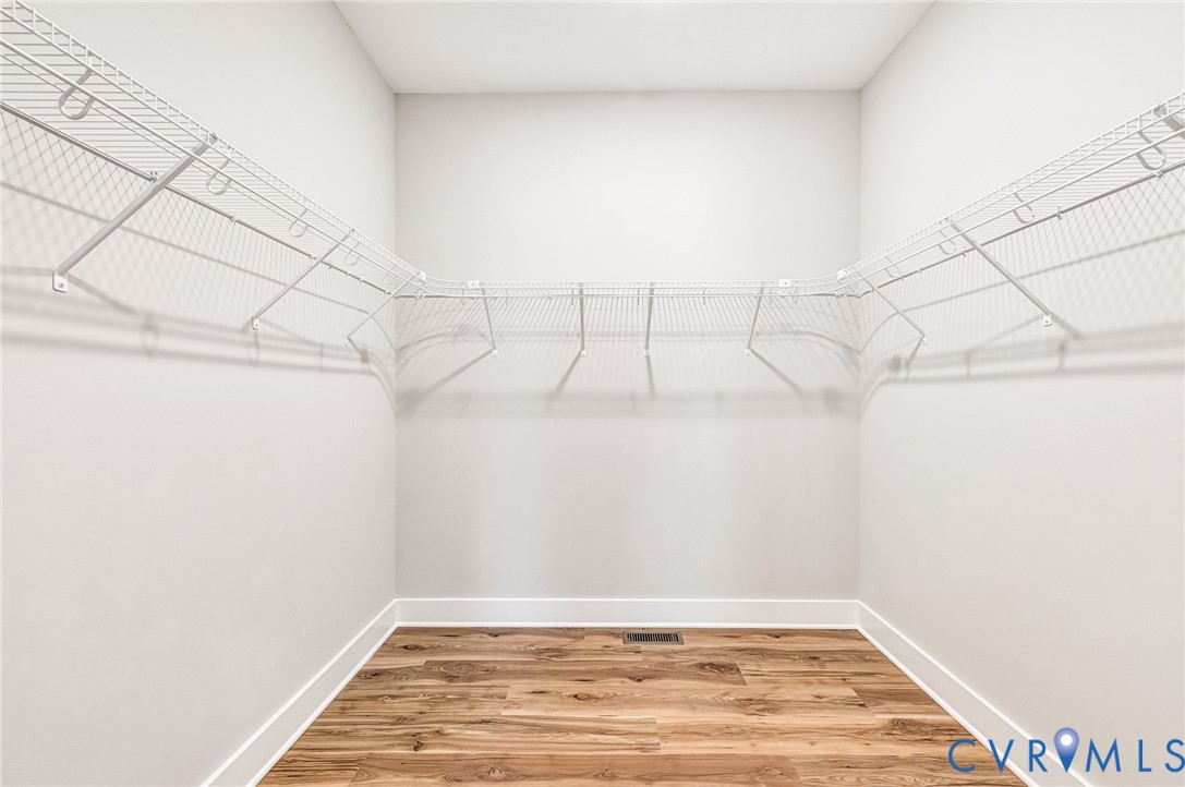 Well-organized closet featuring wire shelving and wood flooring