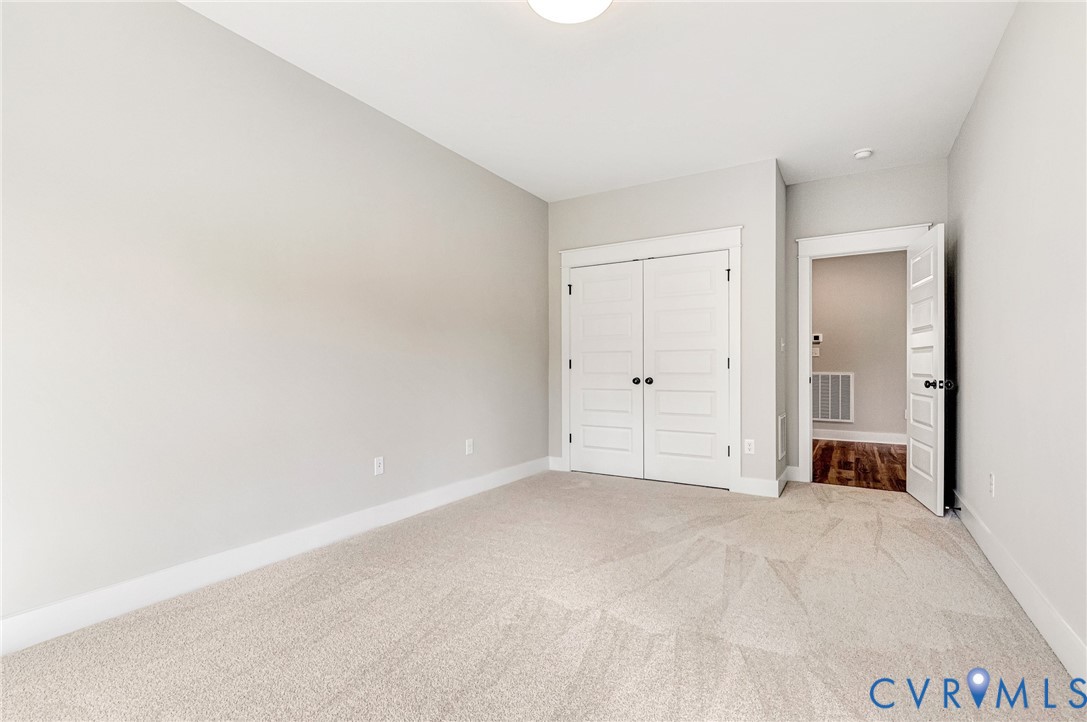 This room features light-colored carpeting, neutral painted walls, and white trim throughout