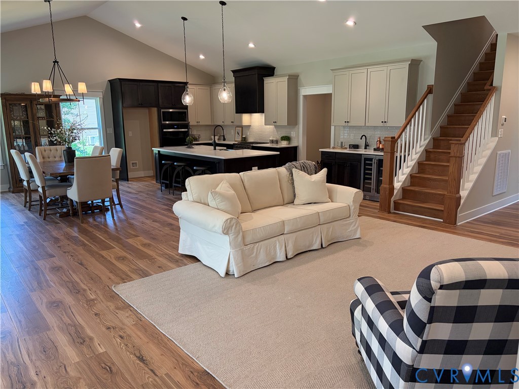 Open-concept living area with vaulted ceiling and recessed lighting