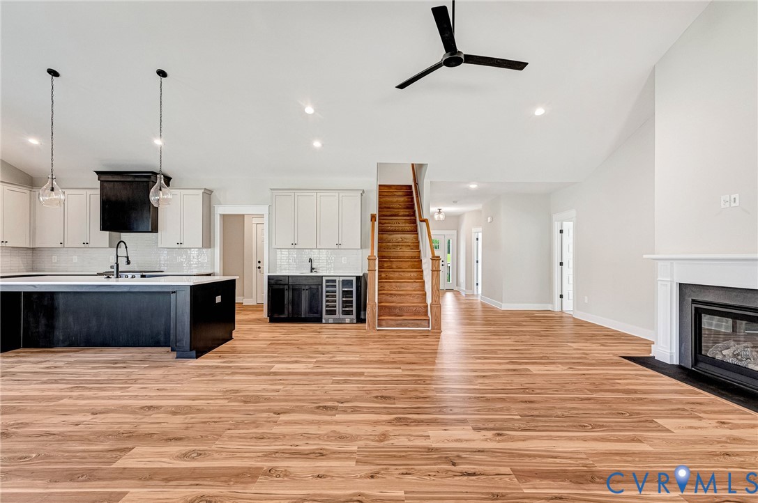 The main living area features hardwood floors, a fireplace with a white mantel, and a ceiling fan