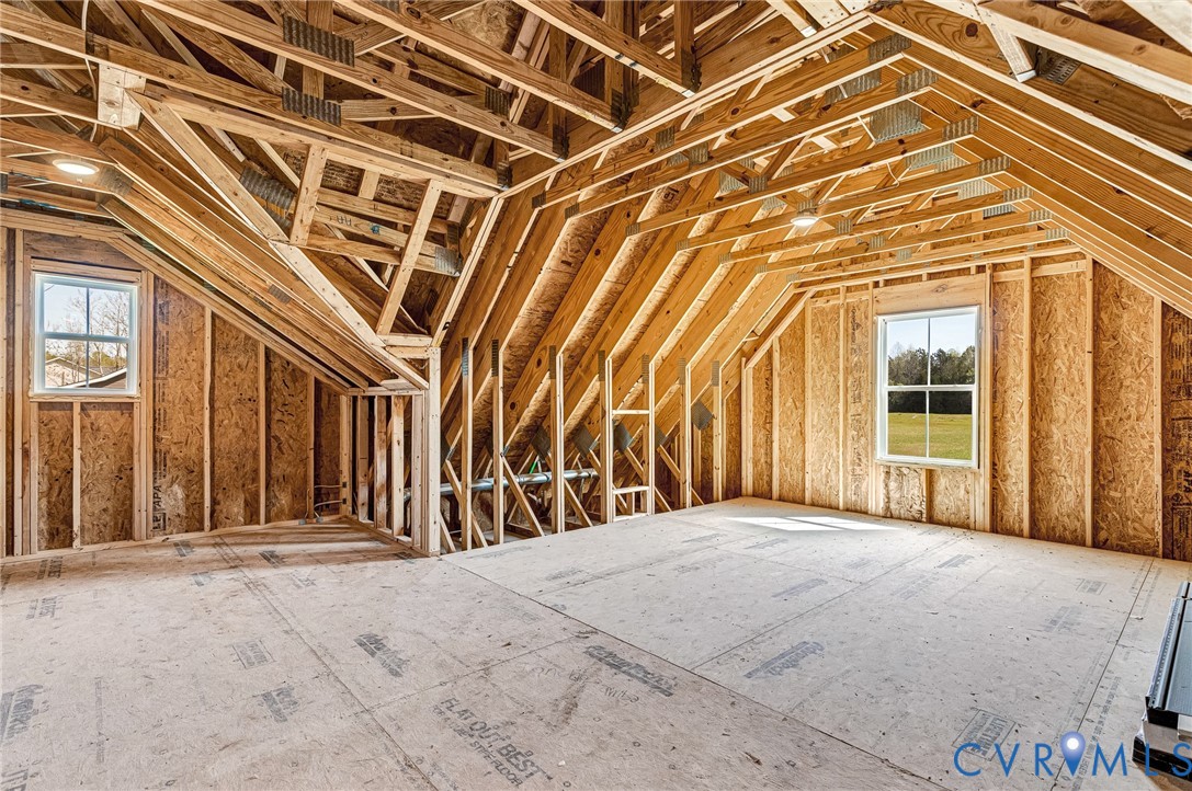 The property features an unfinished room with visible wooden framing and subflooring