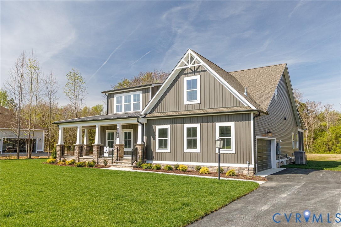The property features a well-maintained lawn, a paved driveway, and an attached garage