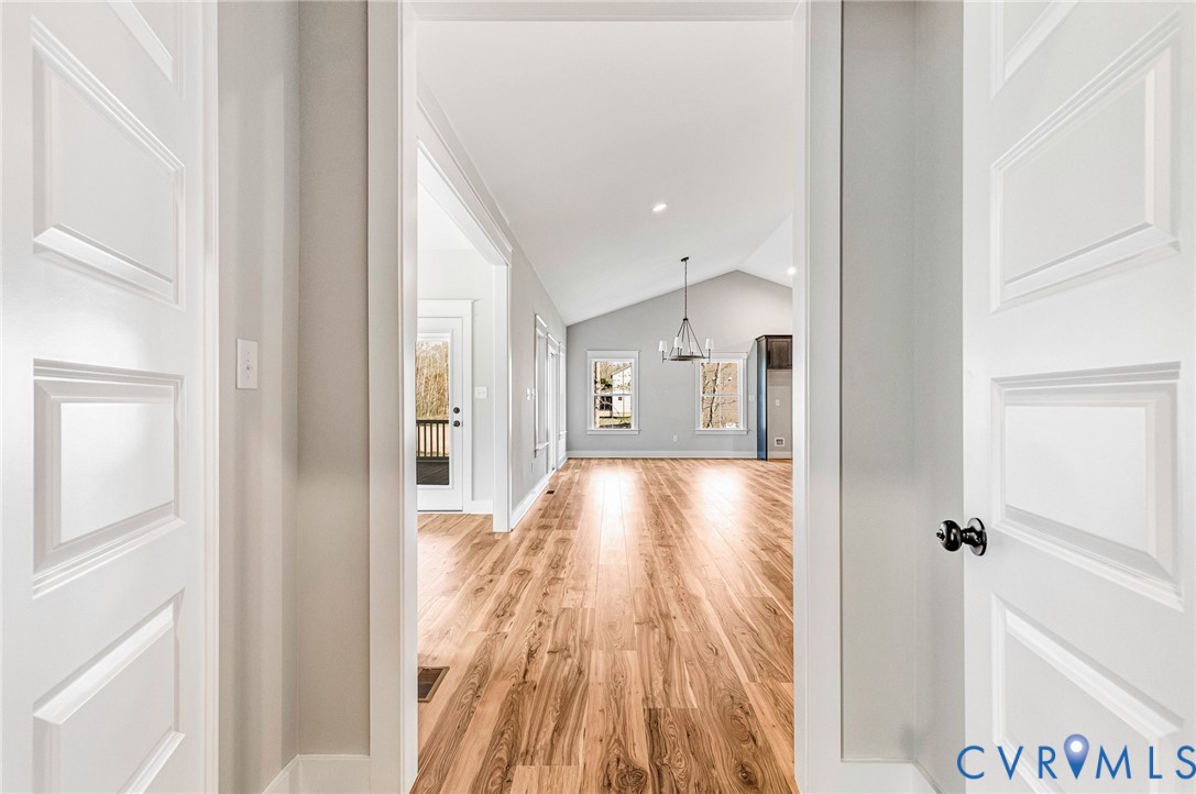 The property features hardwood floors, vaulted ceilings, and a decorative chandelier, creating an inviting atmosphere