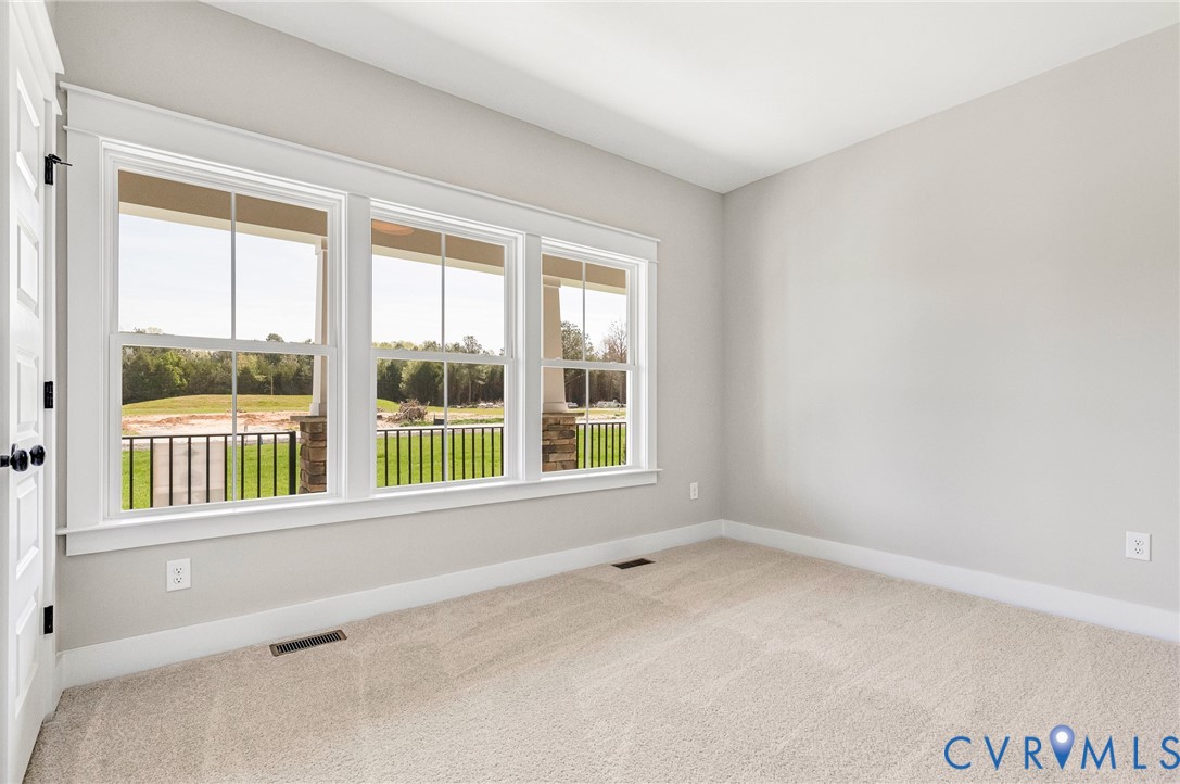 Room featuring light-colored carpet, neutral painted walls, and a white door with black hardware