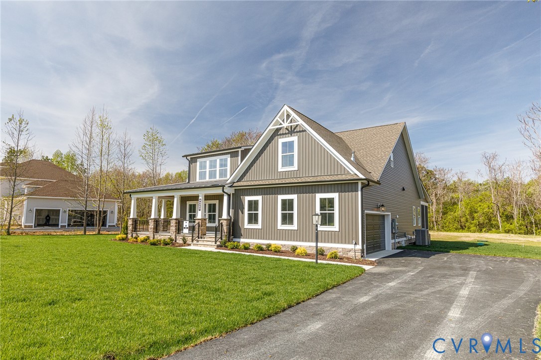 The property features a well-maintained lawn, a paved driveway, and an attached garage