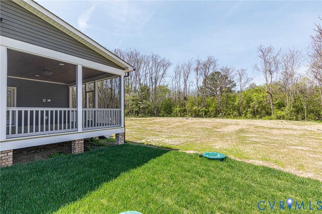 The property features a screened-in porch with white railings and gray siding, supported by brick pillars