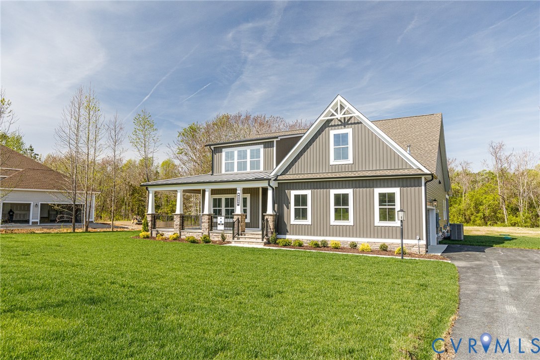 The property features a well-maintained lawn and a paved driveway, leading to the home with gray siding and white trim