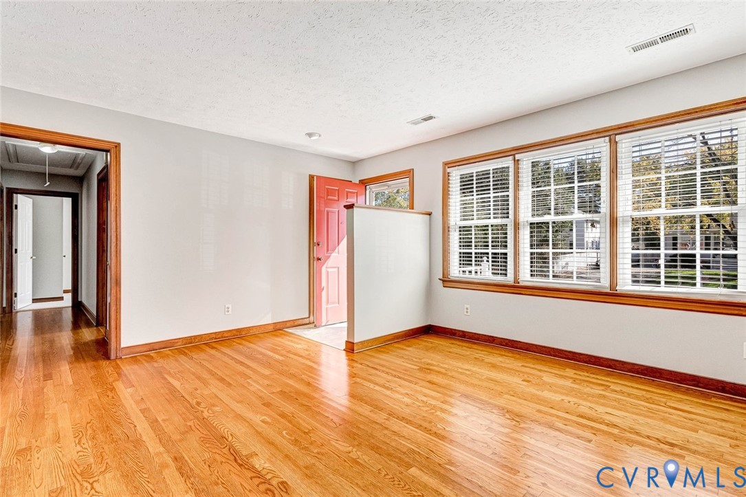 Wood-finish flooring, multi-pane windows with wood-trim casings, and a half-height partition wall