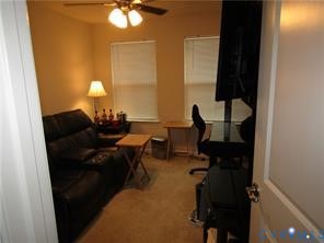 Room featuring neutral wall tones, carpeted flooring, two dual-pane windows with integrated blinds, and a ceiling-mounted light fixture with four-blade fan